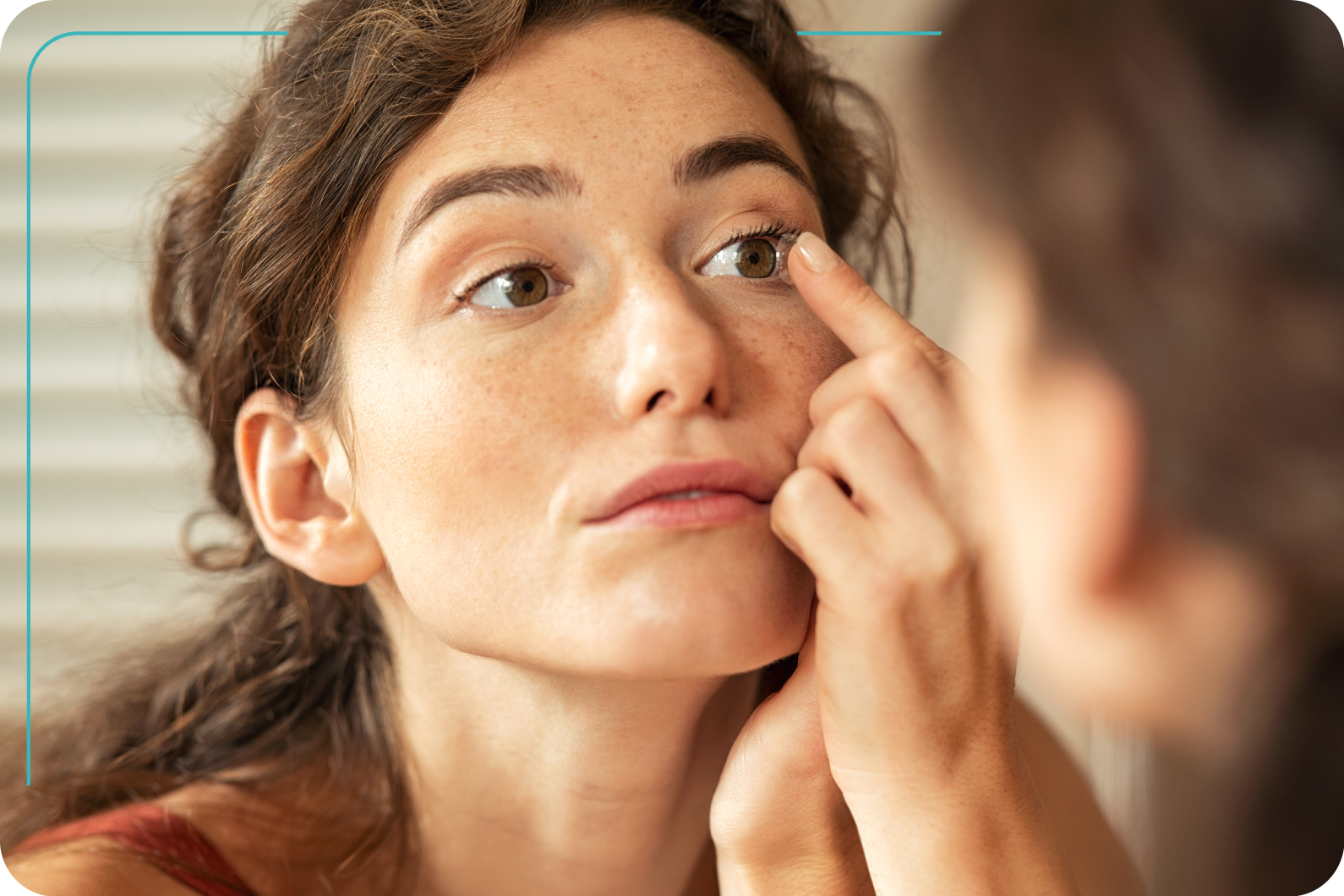 Mujer joven comenzando a colocar sus lentes de contacto