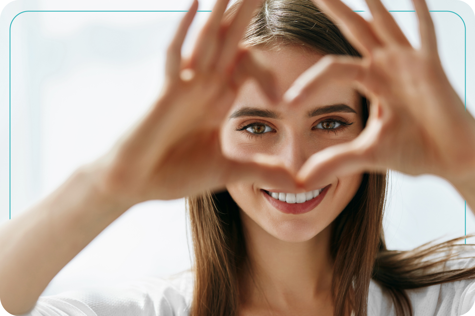 Retrato de mujer haciendo un corazón con las manos y enfocando sus ojos