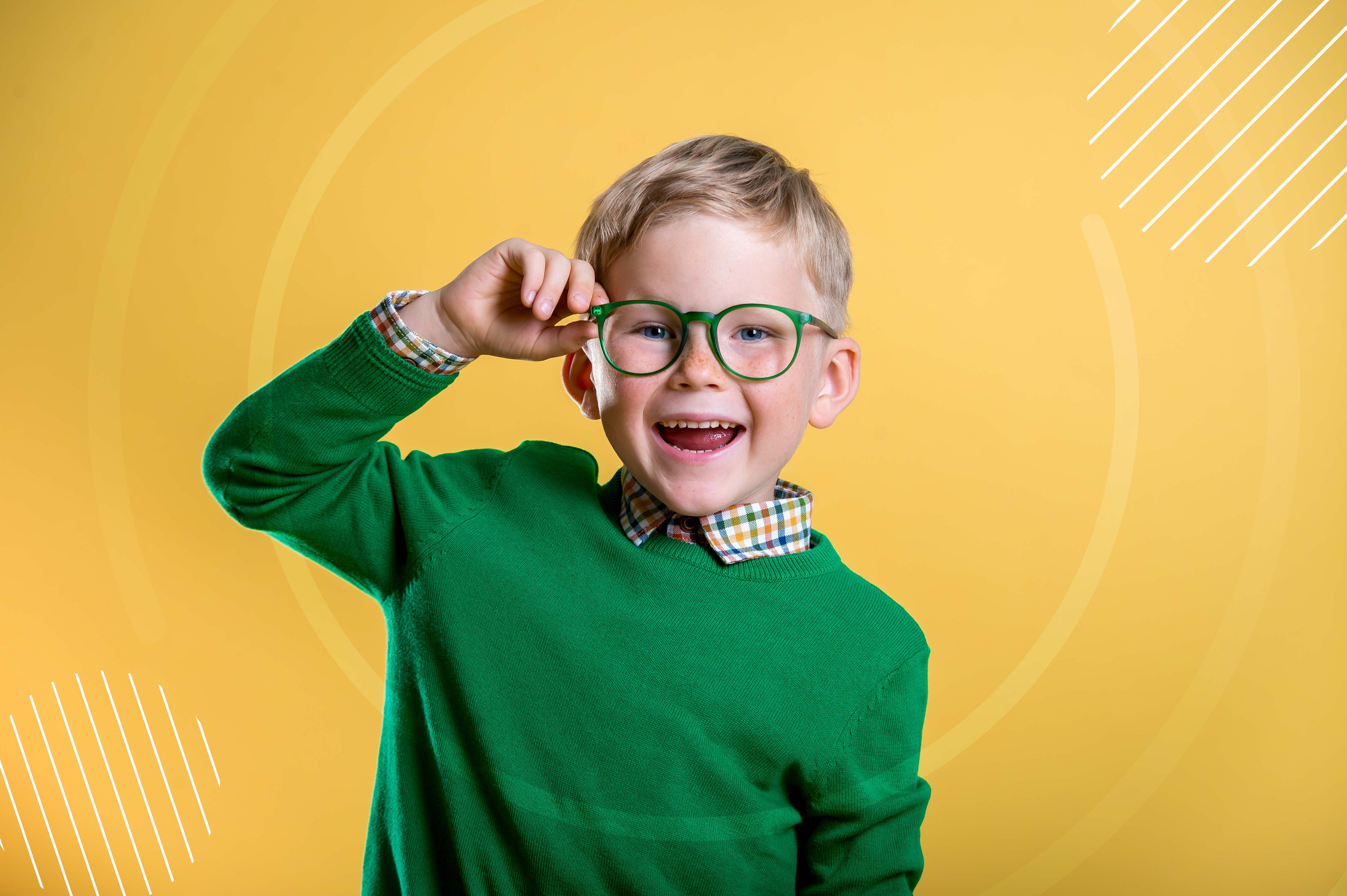 Retrato de niño con  suéter verde a juego con el armazón de los lentes